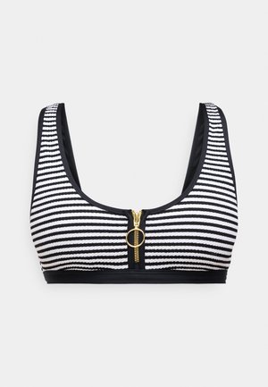 Schwarz-weißer gestreifter Bralette mit einem Reißverschluss auf der Vorderseite, der mit einem goldenen Ringgriff versehen ist. Weiches Material und breite Träger sorgen für zusätzlichen Komfort.