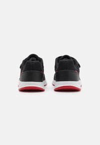Zapatillas deportivas negras con tejido de malla, acentos de cuero, mediasuela blanca y suela roja. Cuenta con un talón redondeado y un collar acolchado.