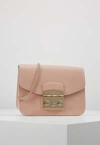 Piccola borsa in pelle saffiano rosa blush con finitura testurizzata, dotata di tracolla in catena dorata e chiusura con gancio dorato, esposta su una superficie bianca contro uno sfondo grigio chiaro.