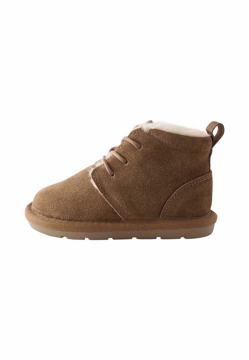 Braune Wildleder-Stiefeletten mit einem weichen weißen Futter, Schnürung vorne und einer robusten Gummisohle. Verfügt über eine kleine Schlaufe hinten für ein einfaches Anziehen.