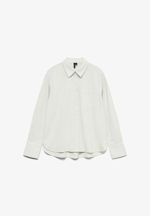 Chemise blanche à manches longues avec col, poche poitrine et larges poignets, présentée à plat sur un fond blanc.