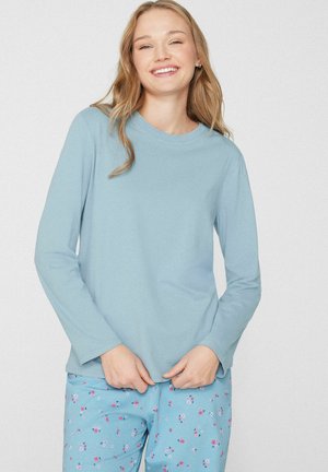 Lichtblauw hemd met lange mouwen, gemaakt van zacht katoen, met een ronde halslijn. Gecombineerd met blauwe pyjamabroek met patroon, versierd met kleine bloemmotieven.