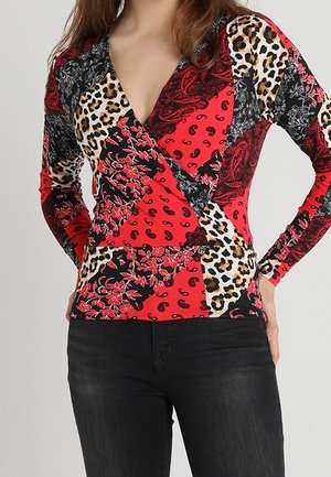 Rotes Langarmoberteil mit V-Ausschnitt, das mit einem Patchwork-Muster aus floralen, Paisley- und Leopardenmotiven in Schwarz, Rot und Beigetönen versehen ist.