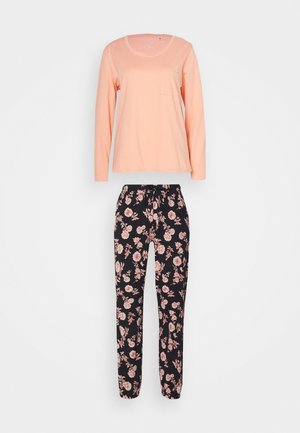 Helles Pfirsichfarbenes Langarmoberteil mit rundem Ausschnitt und Tasche, kombiniert mit schwarzen Jogginghosen mit Blumenmuster und einem Kordelzugbund.