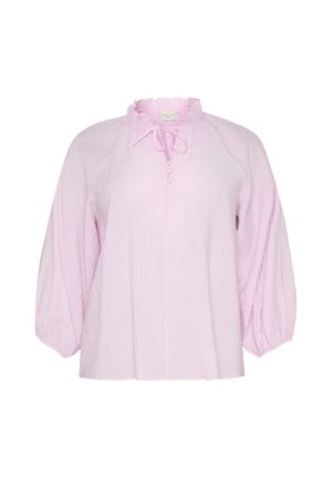 Heled roosa pluus, millel on tekstuuriga kortsus kude, ümar kaelus rippuva äärisega ja sidumise detailiga. Omab puhv-õlgu ja lahedat lõiget.