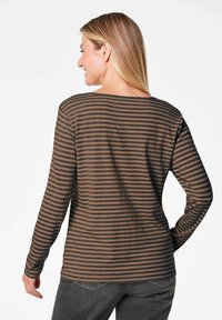 Gestreiftes langärmeliges Shirt in Braun und Schwarz, aus weichem Stoff, mit runder Ausschnitt, slim fit, gerader Schnitt und minimalen Details.