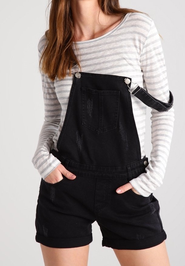 Black denim overalls with distressed details, featuring adjustable straps and a front pocket, paired with a gray striped long-sleeve shirt.