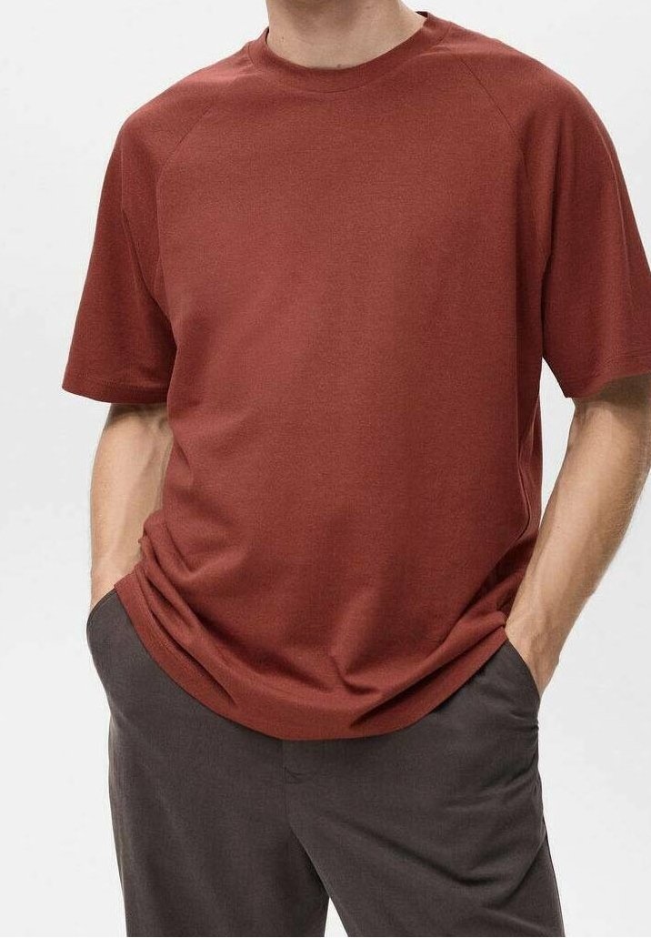 T-shirt rouge à manches courtes en tissu doux et texturé avec une coupe décontractée. Il dispose d'un col rond et de manches raglan.