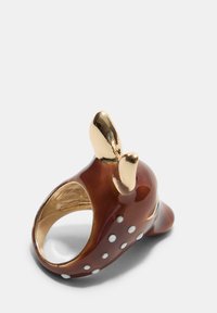 Anello marrone lucido con pois bianchi, con accenti dorati e orecchie. La forma curva esalta il design giocoso.