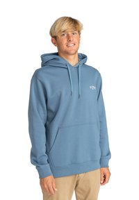Sudadera de algodón azul con bolsillo tipo canguro, capucha ajustable con cordón y logo en el frente. Textura suave y puños acanalados. Corte casual.