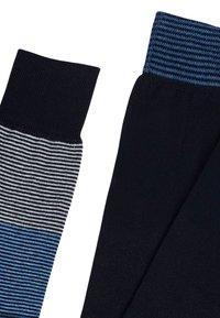 Calzini neri e a righe presentano un bordo a costine con accenti blu. Un calzino è completamente nero, mentre l'altro ha righe orizzontali nere, bianche e blu.