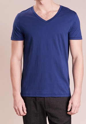 Blaues kurzärmliges V-Ausschnitt-T-Shirt aus glattem, leichtem Stoff. Mit einem dezenten Logo-Detail am Saum. Schlichtes, tailliertes Design.