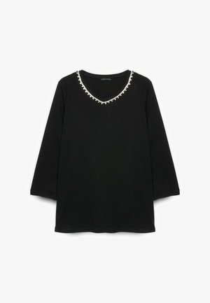 Schwarzes Langarmshirt mit V-Ausschnitt, der mit kleinen weißen Perlenverzierungen am Hals geschmückt ist.