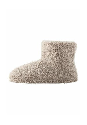 Beige fluffiga stövlar gjorda av texturerad tyg, med en midjehöjd och rund tå samt en mjuk, plyschig yta.