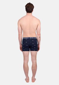 Boxer shorts pour hommes bleu marine avec un motif d'ours vert et blanc, ceinture élastique avec logo, et un design confortable et ajusté.