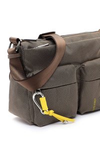 Borsa marrone con texture, dotata di tracolla staccabile, due tasche frontali e un accento giallo. Accessori in argento per attacco o decorazione.