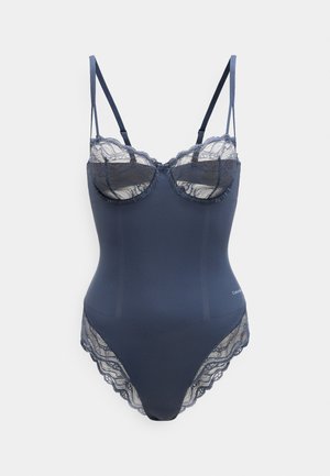 Tumesinine bodysuit, mis on valmistatud siledast kangast ja millel on pitsaktsendid. Sellel on struktureeritud rinnahoidja, reguleeritavad õlapaelad ja laineline äär.