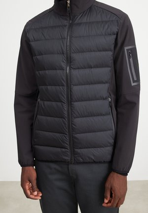 Czarna pikowana kurtka z pełnym zapięciem na zamek z przodu, zapinanymi na zamek bocznymi kieszeniami, gładkimi rękawami oraz kieszenią na zamek na górnej części lewego ramienia.