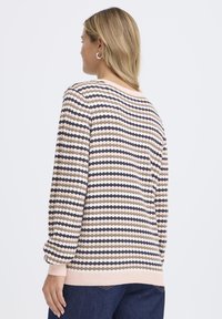 Adīts džemperis ar svītrainu rakstu bēšā, persiku krāsā un tumši zilā krāsā. Apaļa kakla izgriezums un ribotie aproces gali. Maiga tekstūra, vaļīgs piegriezums un skats no aizmugures.