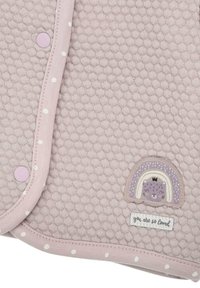 Helles rosa, gestepptes Gewebe mit Punkten, mit einem kleinen Regenbogen-Aufnäher und dem Text "du bist so geliebt" auf einem rechteckigen Etikett.