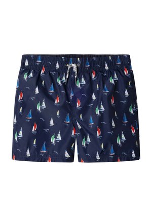 Bañador corto azul marino con estampados multicolores de veleros, cintura elástica y cordón blanco con detalles de texto en negro.