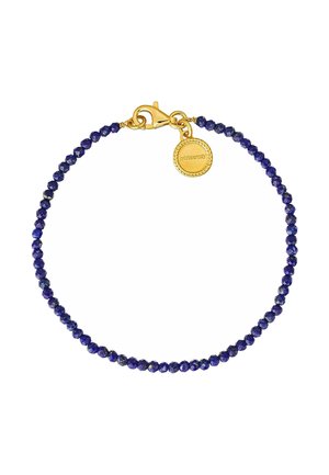 Pulsera de cuentas de lapislázuli que presenta pequeñas piedras azules facetadas, asegurada con un cierre dorado y un charm circular dorado.