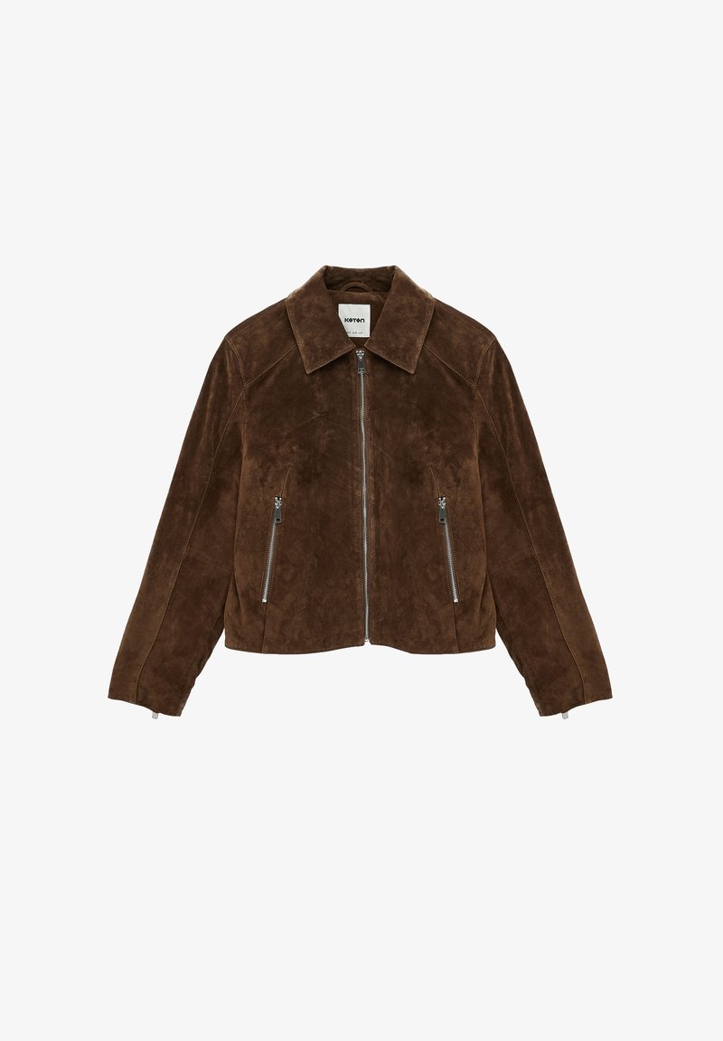 Veste en daim marron avec fermeture éclair frontale, deux poches latérales zippées et col pointu, présentée sur fond blanc.