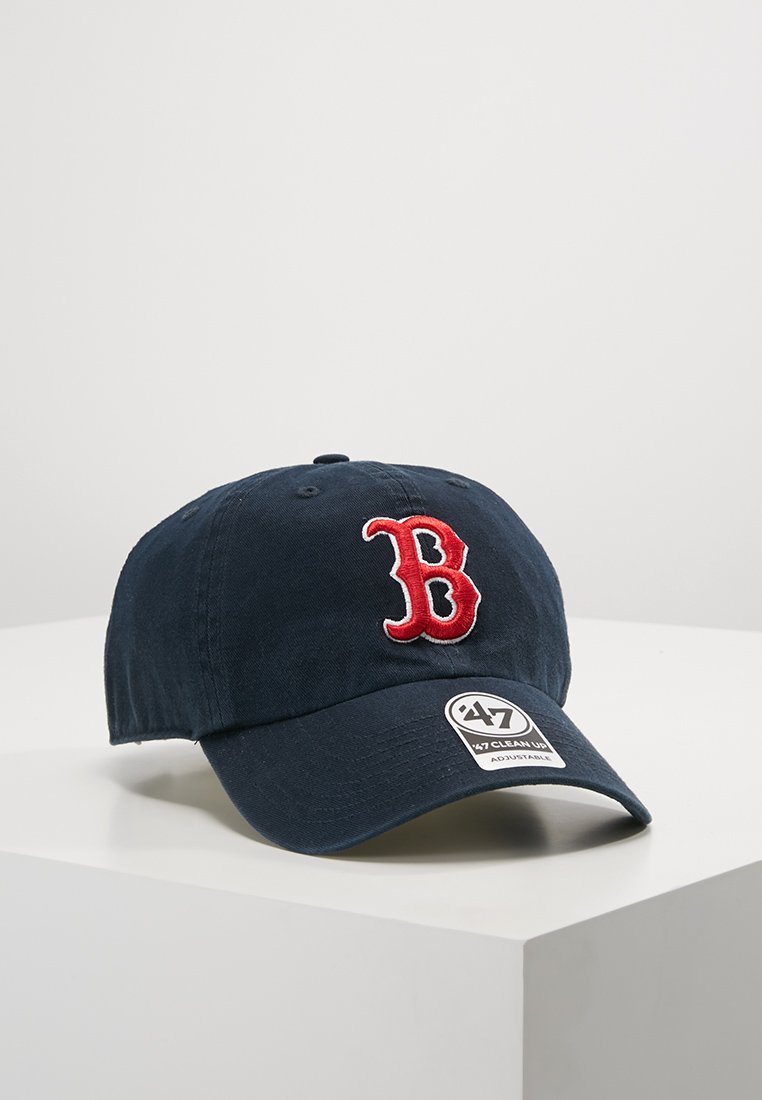 Navy blue baseball cap made of cotton, featuring a red embroidered "B" logo on the front and a curved brim. Adjustable strap at the back.