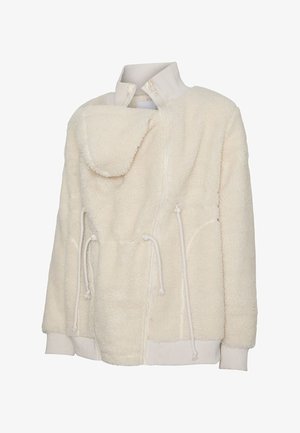 Jakna od sherpa flisa boje kreme s visokim rebrastim ovratnikom, prednjim patentnim zatvaračem, podesivim vezicama i rebrastim manšetama i rubom.