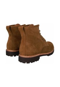Botas de tobillo de ante marrón, con puntas redondeadas, seis ojetes, tejido texturizado, suela de goma con surcos pronunciados y costuras en contraste.