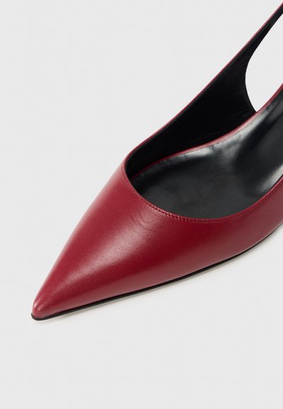 Κόκκινη αντλία από δέρμα με μυτερή μύτη και κομψό σχέδιο με κοψίματα, λεία υφή και μαύρο εσωτερικό. Διαθέτει χαμηλό, λεπτό τακούνι.