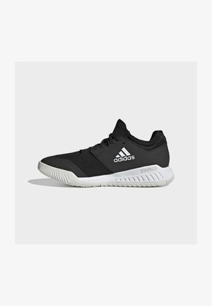 Zapatilla deportiva Adidas negra de corte bajo con suela blanca y logo, suela exterior texturizada para mejor agarre y diseño con cordones, vista de perfil lateral.