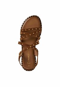 Bruine suède sandaal met kruislings banden, gouden studs langs de rand en een gestructureerde binnenzool met 'MARCO TOZZI' branding.
