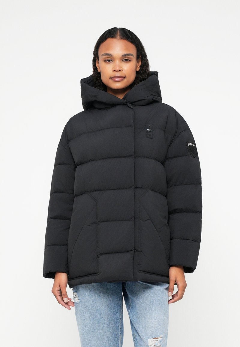 Jachetă puffer neagră cu glugă, având un design capitonat, buzunare laterale și un logo mic pe piept și pe mânecă.