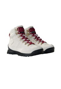 Bottes de randonnée blanches avec des lacets rouge et blanc, œillets en métal et semelles en caoutchouc noir. La tige est en matériau suédé lisse.