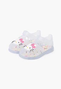 Clear plastic sandals with a Hello Kitty design, featuring a pink bow and black facial details, and a patterned insole with colorful accents.