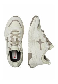 Sneakers bianchi e beige chiaro con tomaia testurizzata, chiusura con lacci, colletto imbottito e suola in gomma con motivo e dettagli screziati.