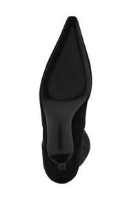 Chaussure à talons hauts noire avec bout pointu, dessus en daim et semelle en caoutchouc lisse dotée de rainures horizontales pour l'adhérence.