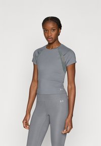 Sivi sportski top s kratkim rukavima, glatkom teksturom i kontrastnim bočnim panelima. Istaknut logo na donjem lijevom dijelu, kroj prilagođen tijelu.