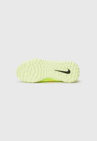 Podeszwa sportowego buta Nike, jasny neonowy żółty kolor z teksturowaną powierzchnią, wzór falisty i małe czarne logo swoosh.