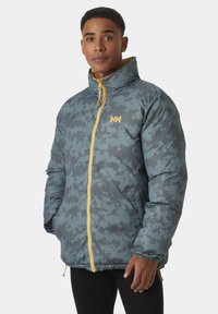 Padded jacket v šedobluém camouflage vzoru se žlutým zipem a logem, s vysokým límcem a elastickými manžetami.