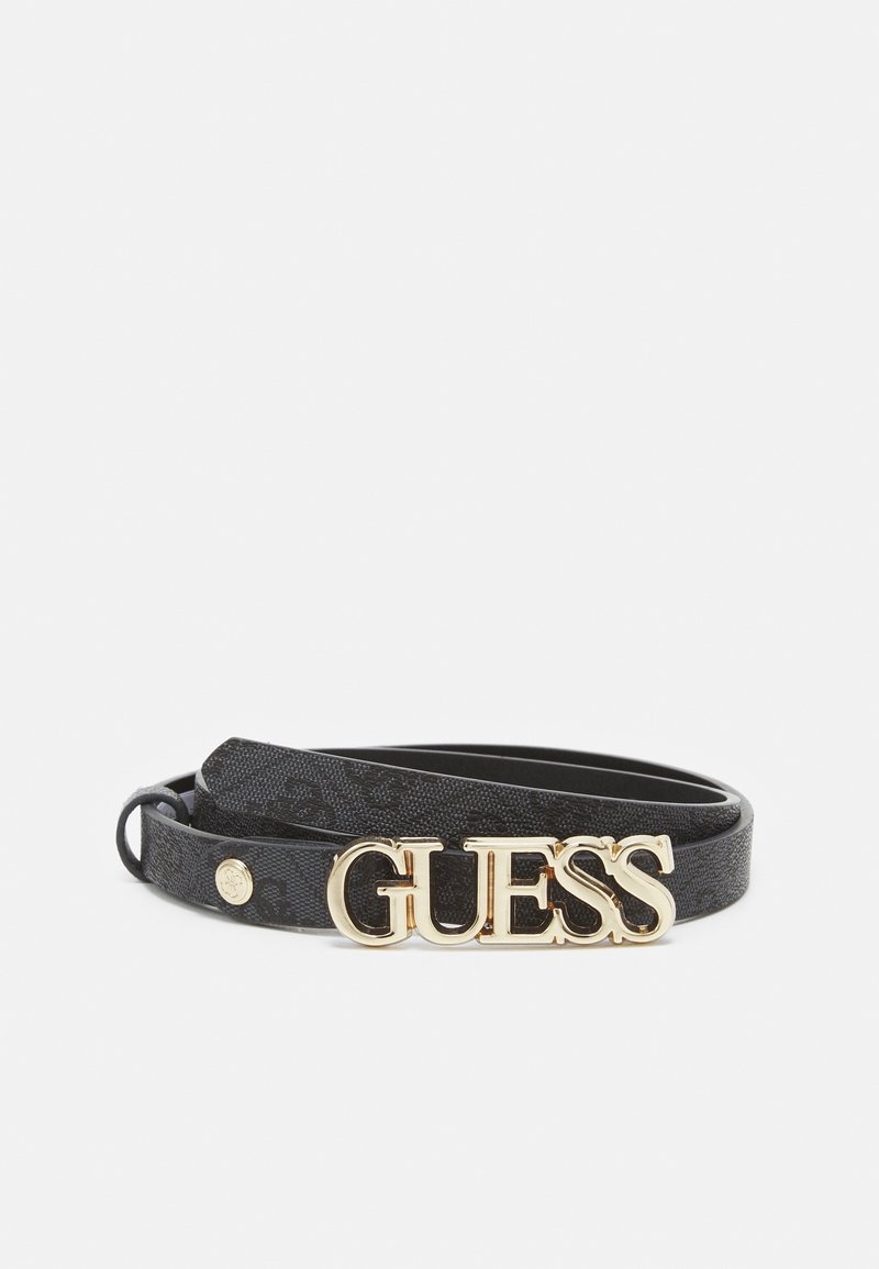 Ceinture en cuir noir avec boucle dorée portant l'inscription "GUESS" et un petit bouton doré sur un fond blanc uni.