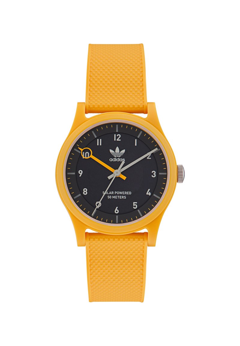 Montre solaire jaune avec un bracelet en caoutchouc texturé, cadran noir avec des marqueurs d'heure blancs et orange, et couronne en acier inoxydable. Étanche jusqu'à 50 mètres.