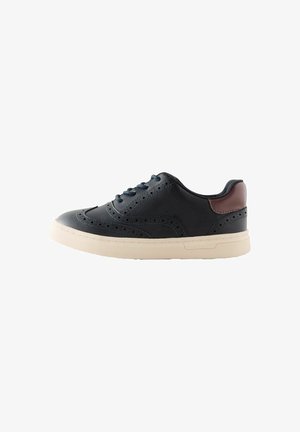 Czarny skórzany sneaker z perforowanymi detalami, płaskimi sznurowadłami i beżową gumową podeszwą; z brązowym akcentem na pięcie.