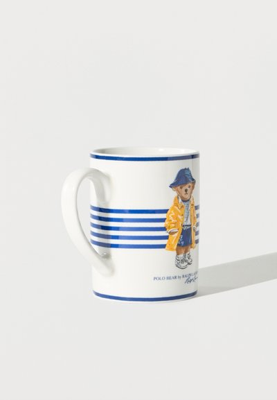 Fehér kerámia bögre kék csíkokkal, oldalán egy maci látható, aki sárga esőkabátot, kék kalapot és tornacipőt visel.