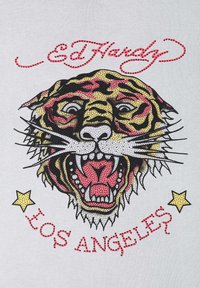 Grafická tričko s řvoucím tygrem se žlutými, černými a červenými vzory. Nápisy "Ed Hardy" a "Los Angeles" jsou tištěny v stylizovaném písmu.