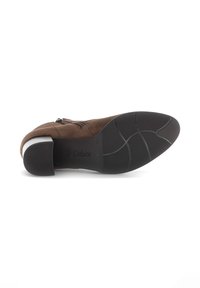 Brown suede ankle boot with a rounded toe, a low heel, and a textured black rubber sole featuring a zigzag pattern for grip.