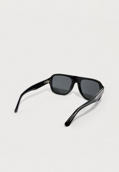 Czarne okulary przeciwsłoneczne z kwadratową oprawką, ciemnymi soczewkami i smukłymi plastikowymi zausznikami. Wyposażone w subtelne metalowe detale po bokach.