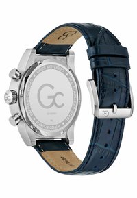Orologio in acciaio inox argentato con cinturino in pelle blu a motivo coccodrillo, cassa rotonda e vetro zaffiro. Presenta movimento svizzero e una fibbia lucida.