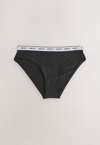 Sous-vêtement style bikini noir avec taille élastique blanche avec le logo "NEXT" répété, posé à plat sur un fond clair.